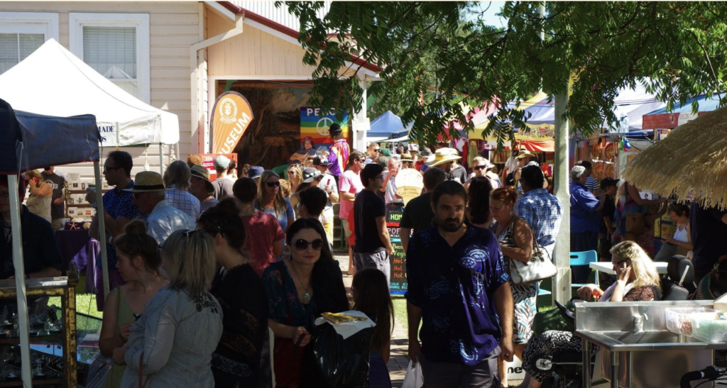 a crowd of visitors at the mullumbimby community market
