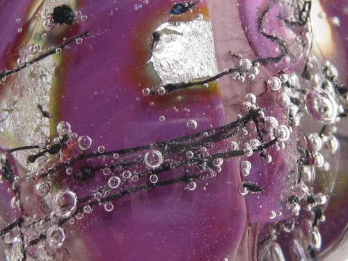 emubead-close-up-cerise-glass-bead-with-metal-inclusions